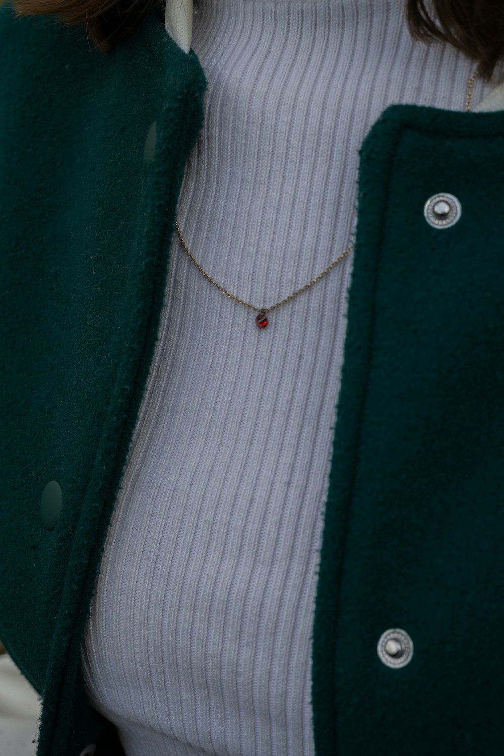 a close up of a woman wearing a green coat