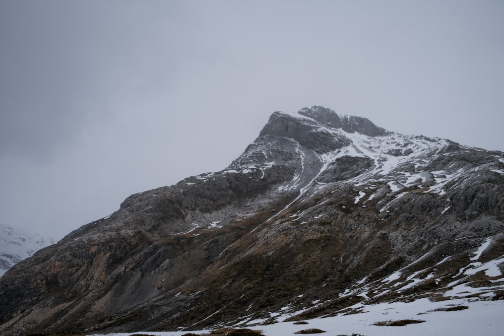 a mountain covered in snow with a few clouds