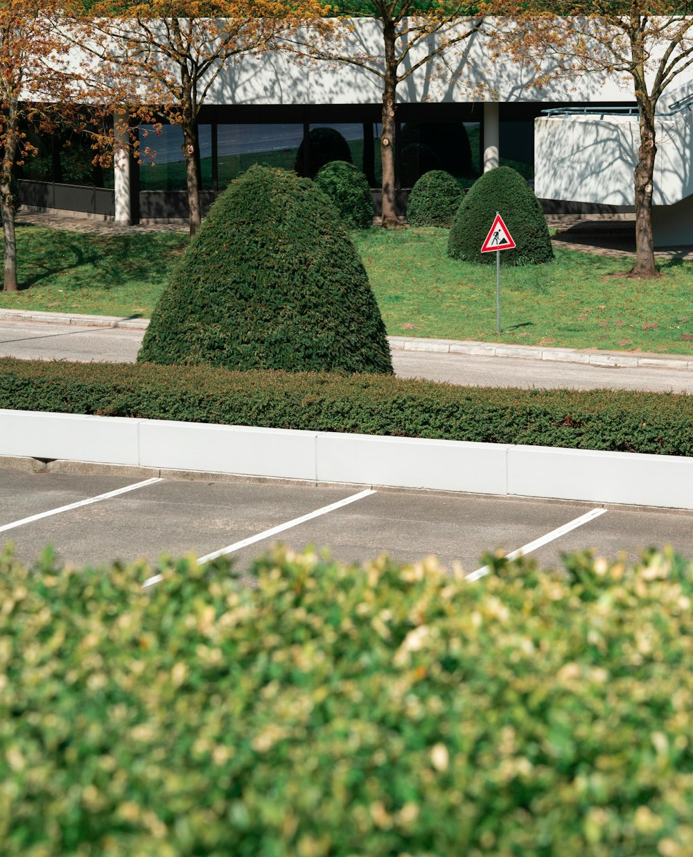 a parking lot next to a building with a sign in the middle of it