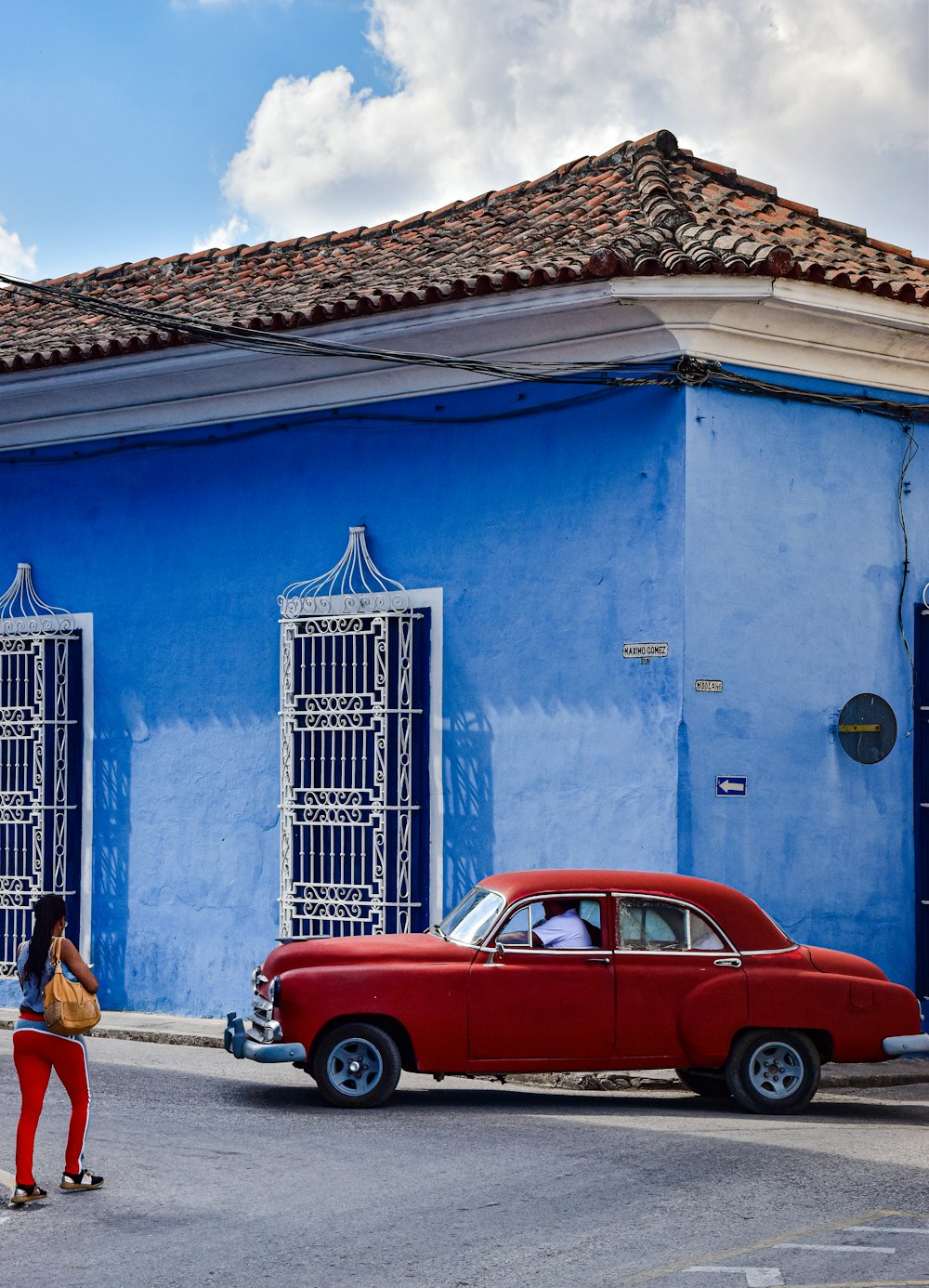a red car parked in front of a blue building