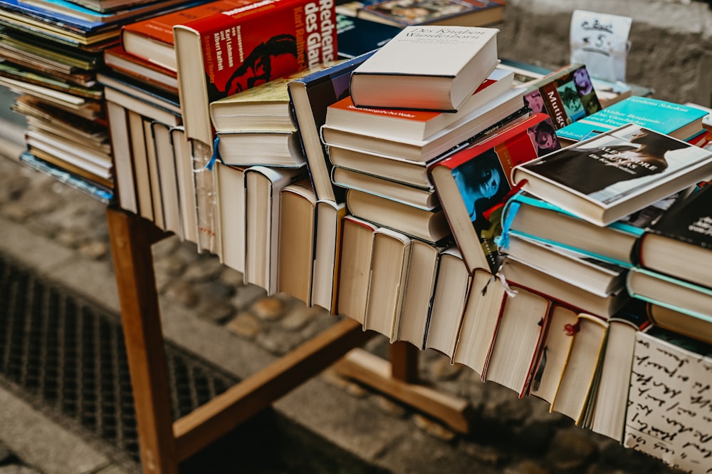 a pile of books sitting on top of a wooden table