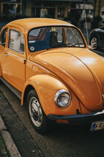 an orange car parked on the side of the road