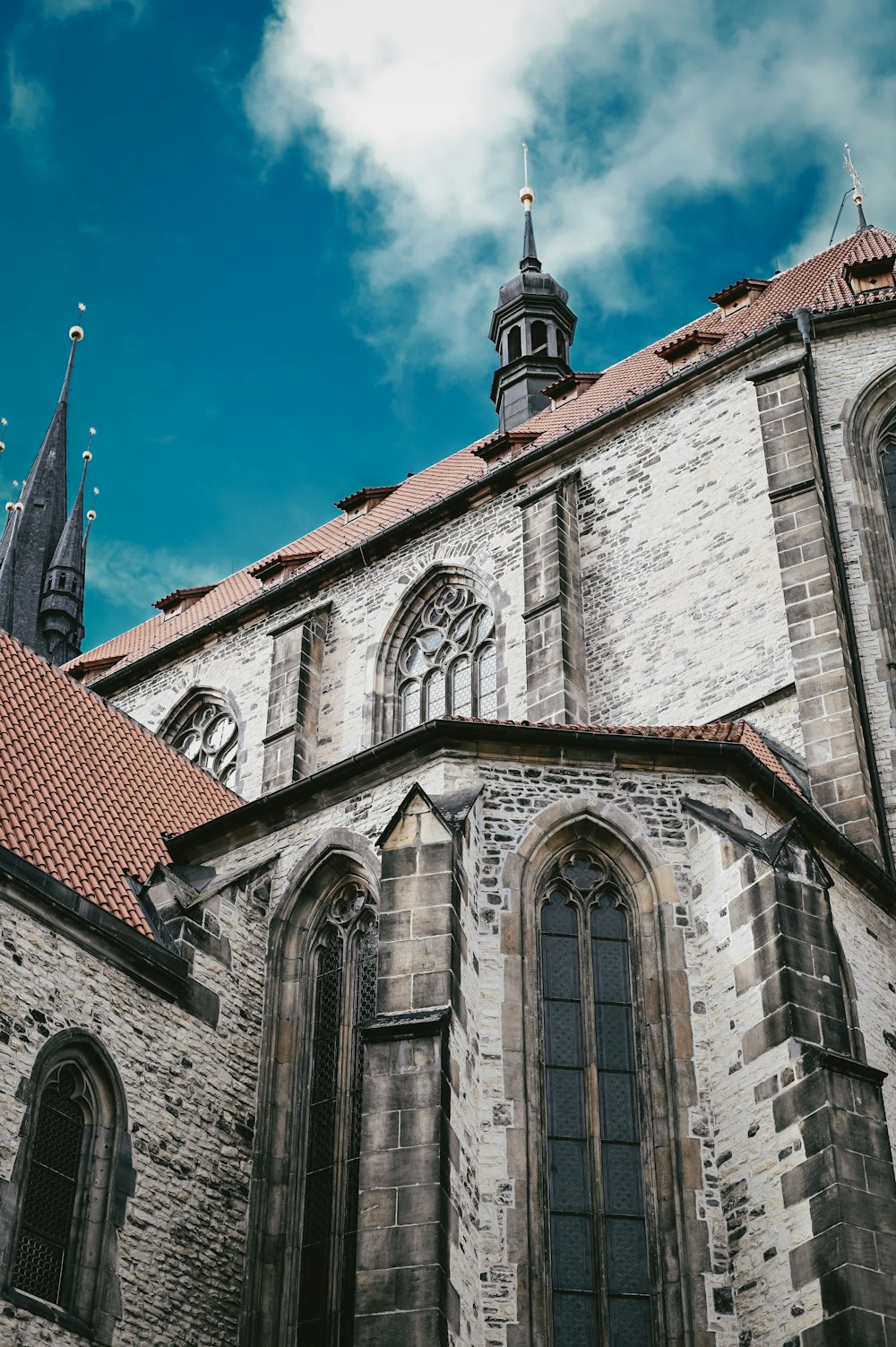 a church with a red tiled roof and steeple