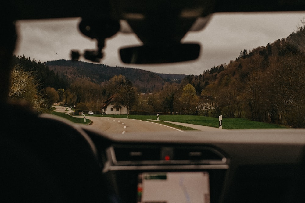 a view from inside a car of a road with a house in the distance