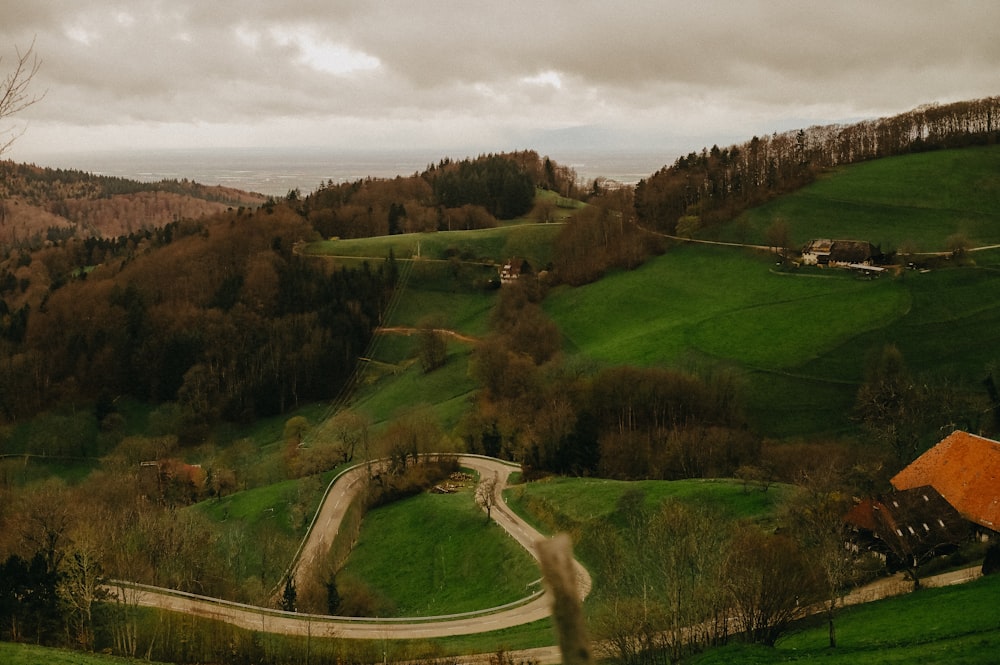 a winding road in the middle of a lush green hillside