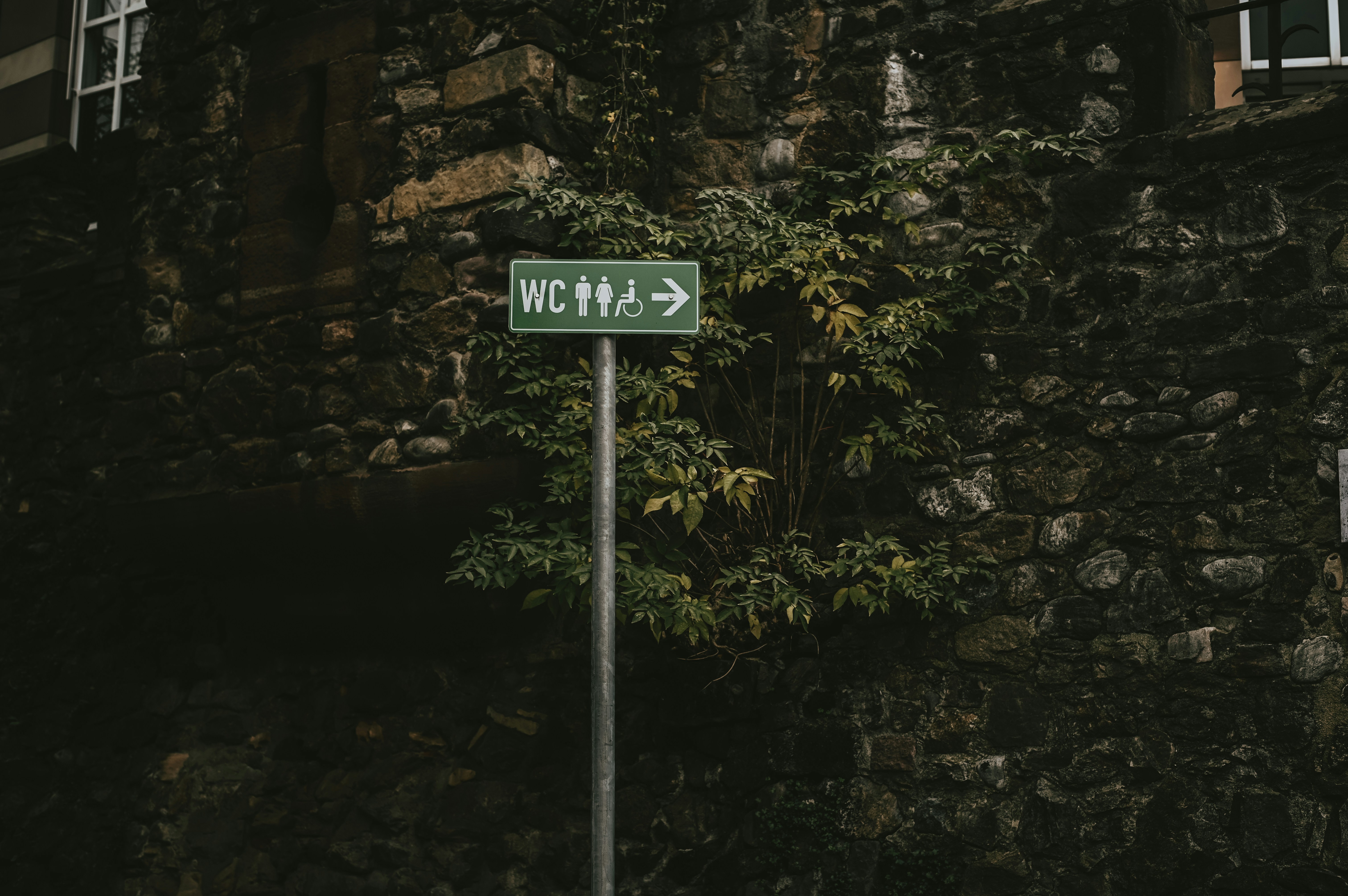 a street sign in front of a stone building