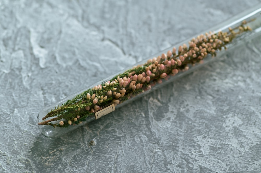 a glass tube filled with flowers on top of a table