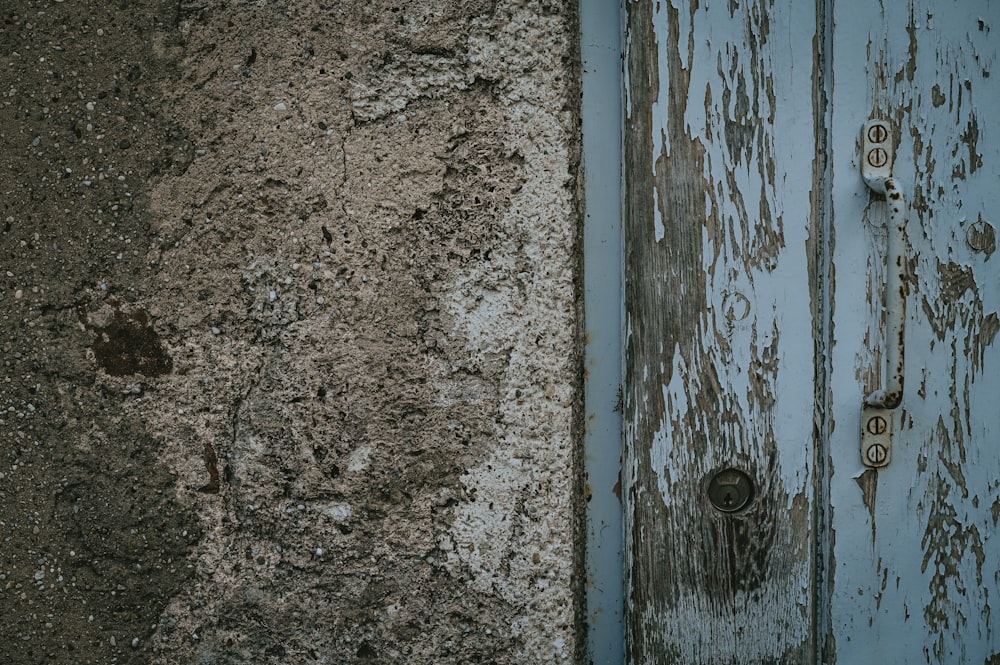 a close up of a blue door with rust on it