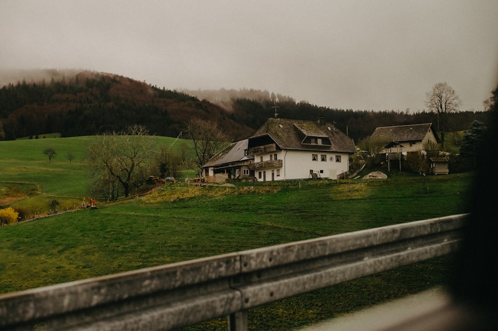 a white house sitting on top of a lush green hillside