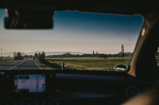 A spacious cab parked beside a scenic highway with green fields in Bihar.