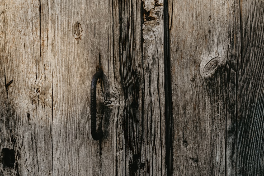 a close up of a wooden door with a metal handle