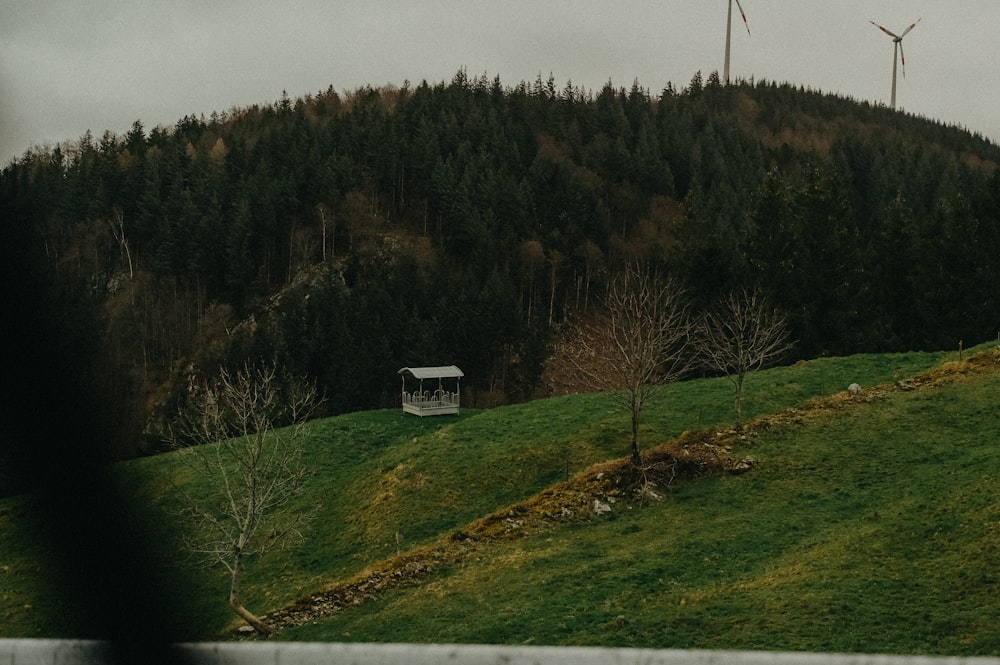 Una casa su una collina con mulini a vento sullo sfondo