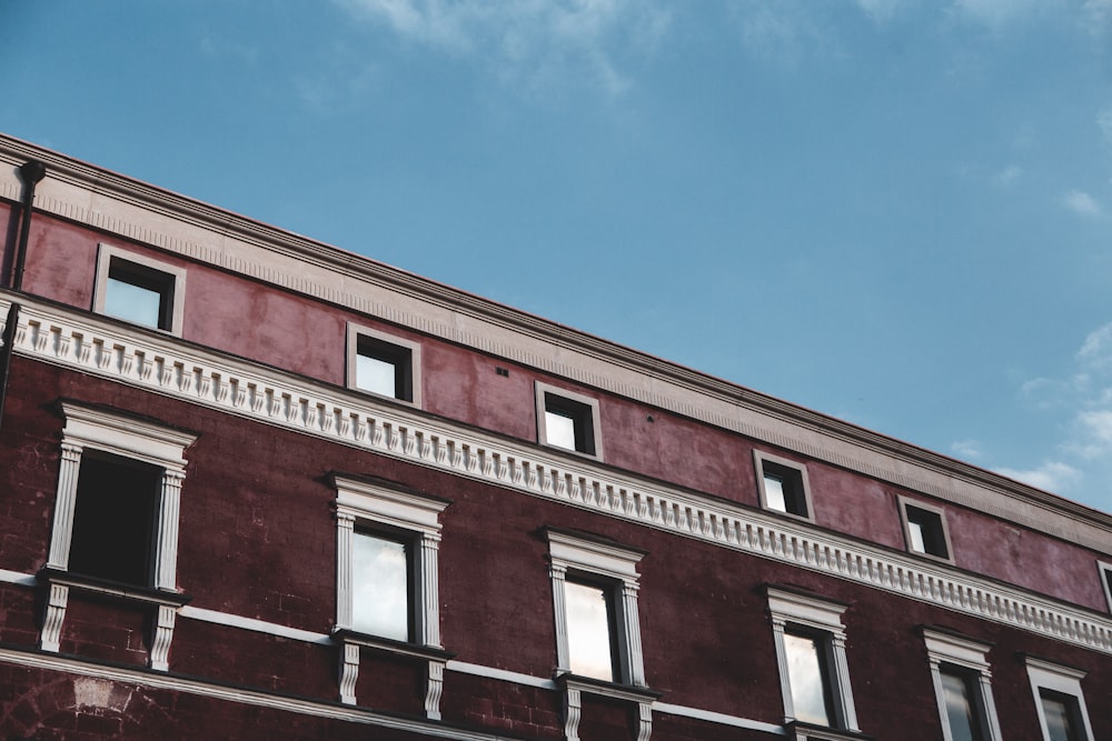 a red building with a clock on the side of it