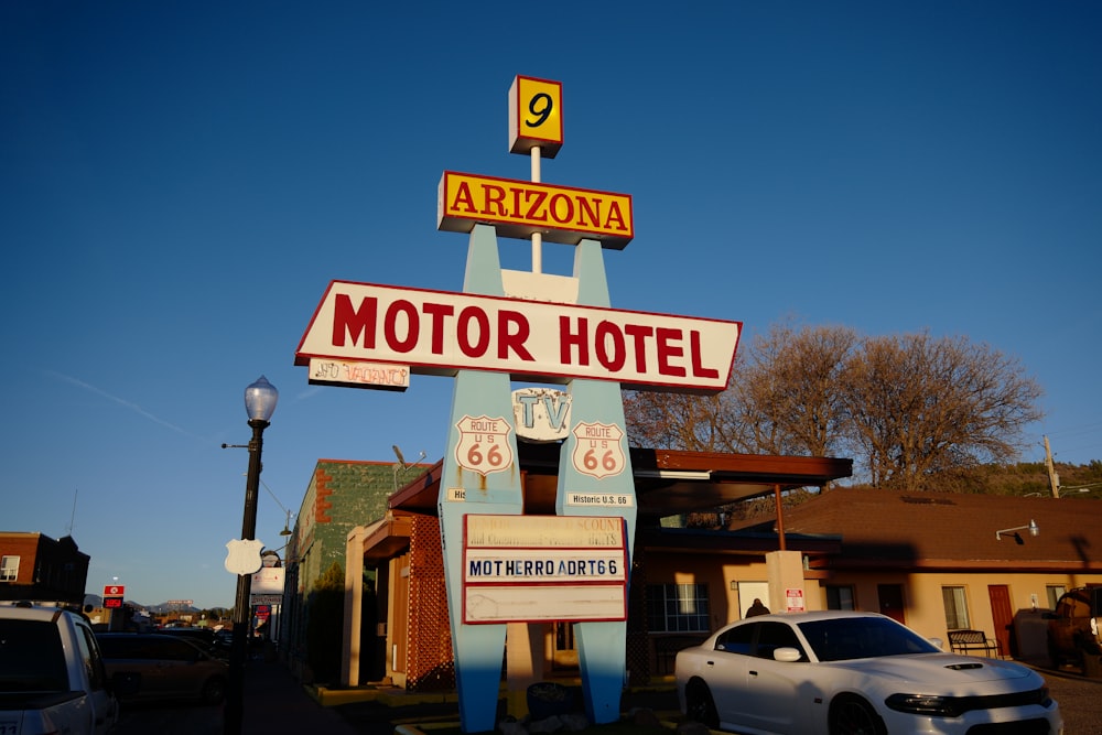 a motel sign with a car parked in front of it