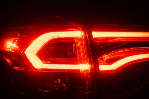 Close-up of a vibrant red LED tail light assembly glowing vividly on a car.