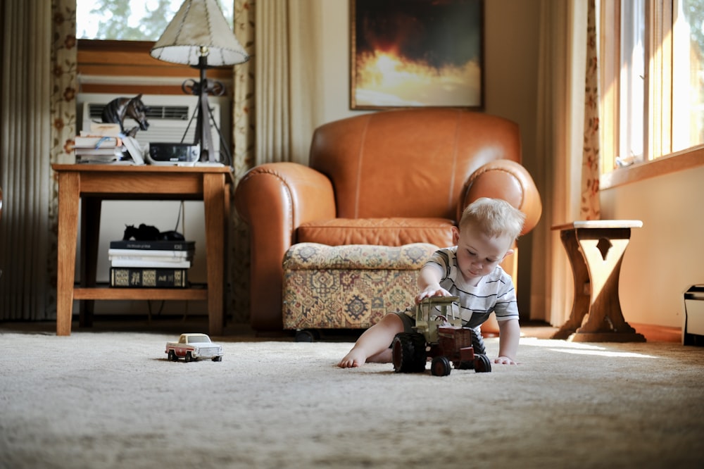 a young boy playing with a toy truck in a living room