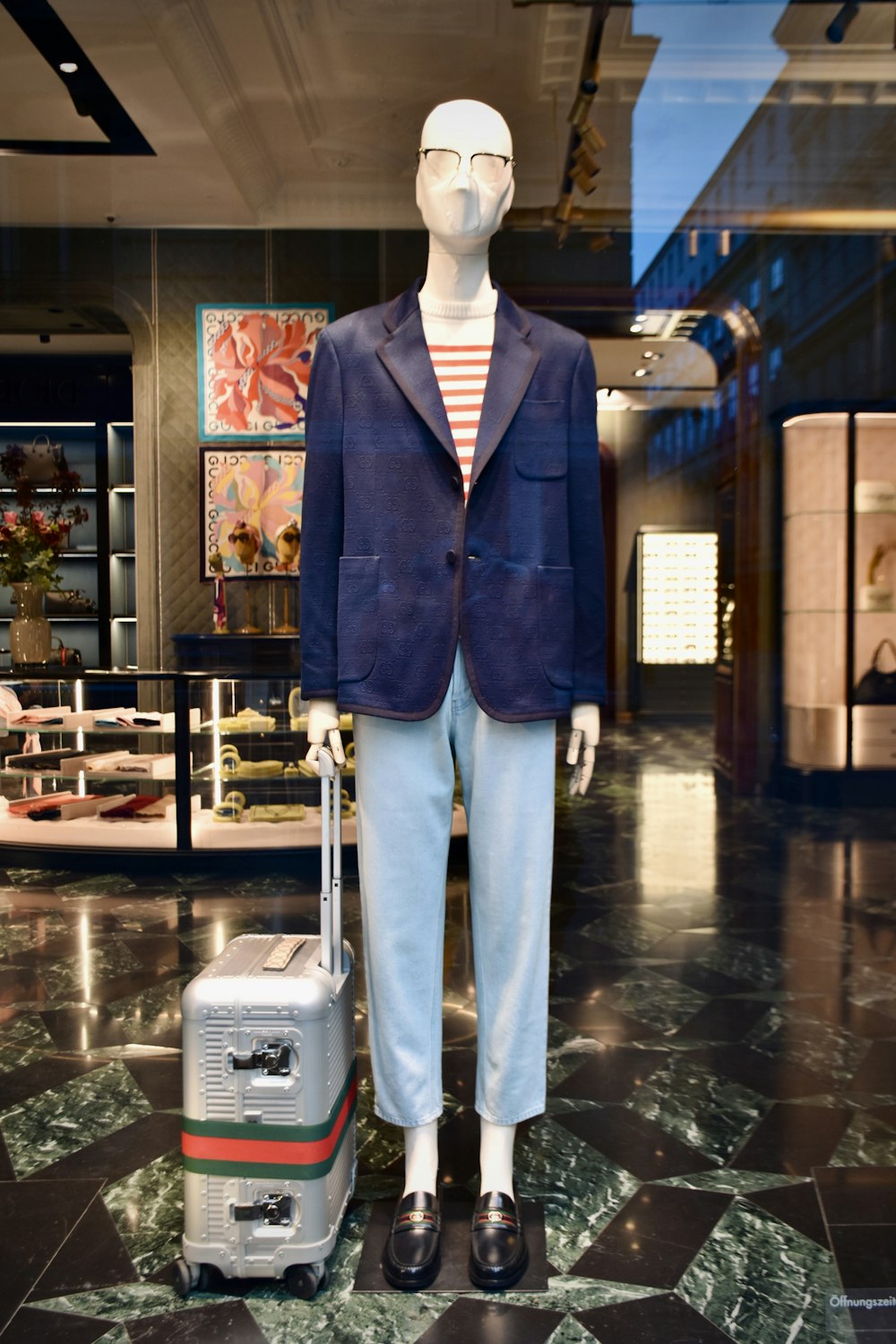 a mannequin dressed in a suit with a suitcase