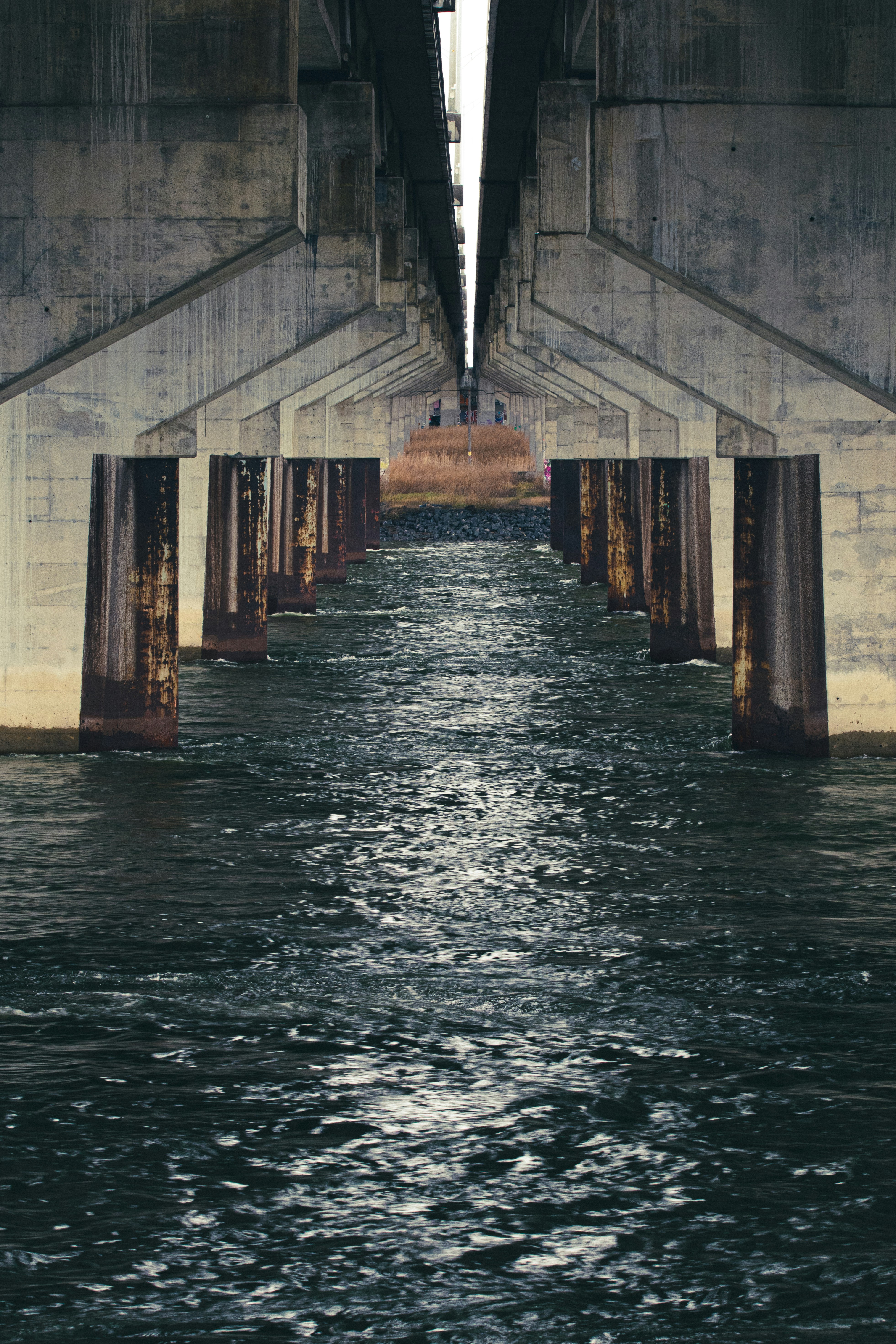 a view of the underside of a bridge over a body of water