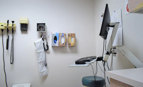 a room with a desk, phone, and other items on the wall