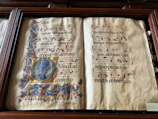A collection of handwritten musical notes and sacred texts illuminated by candlelight.