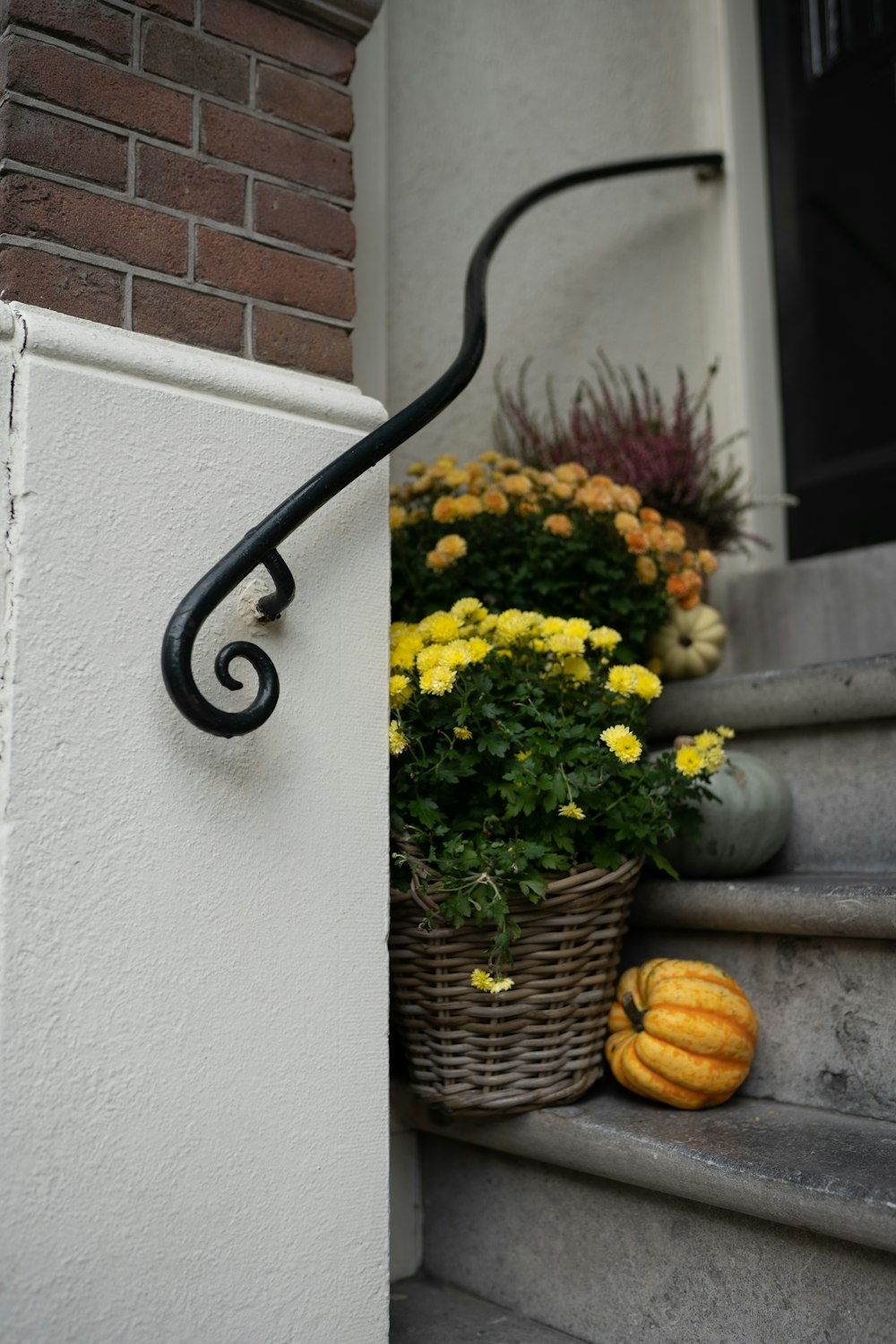 a basket of flowers sitting on the steps of a house