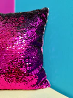 Close-up of a magenta and teal patterned throw pillow from ohmyqart's homeware line.