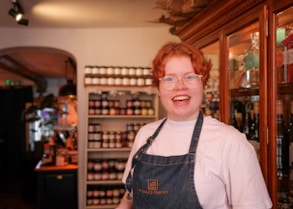 Friendly shopkeeper assisting a smiling customer in a cozy store environment.