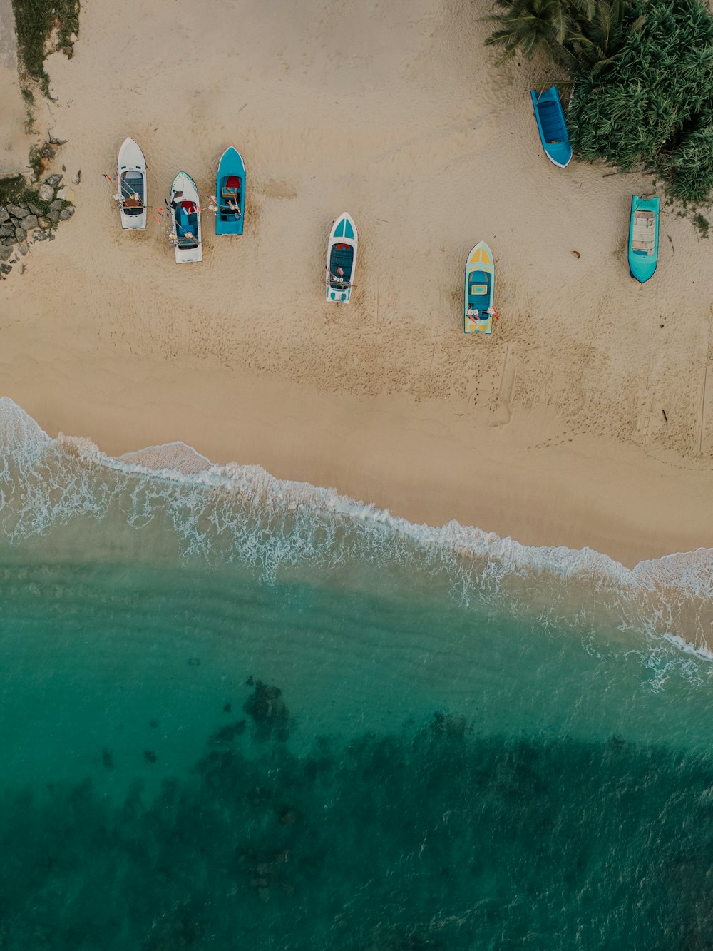 un groupe de bateaux assis au sommet d’une plage de sable