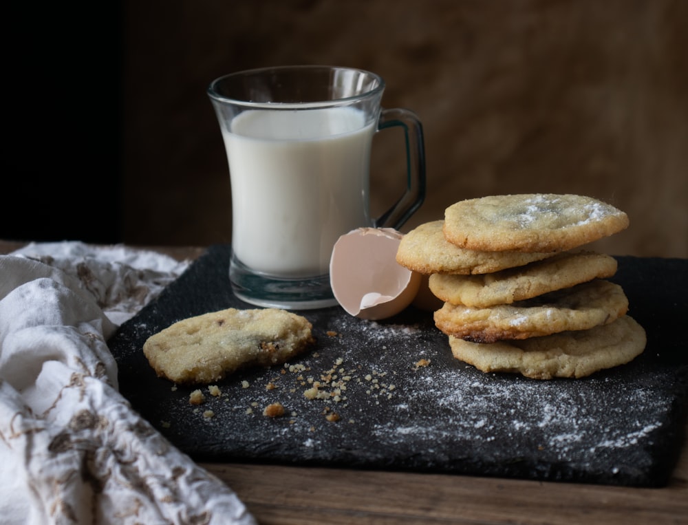 a stack of cookies next to a glass of milk