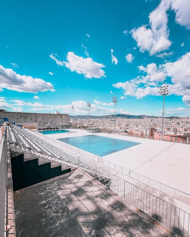 Wide angle view showing the pool, surrounding deck, and panoramic cityscape.