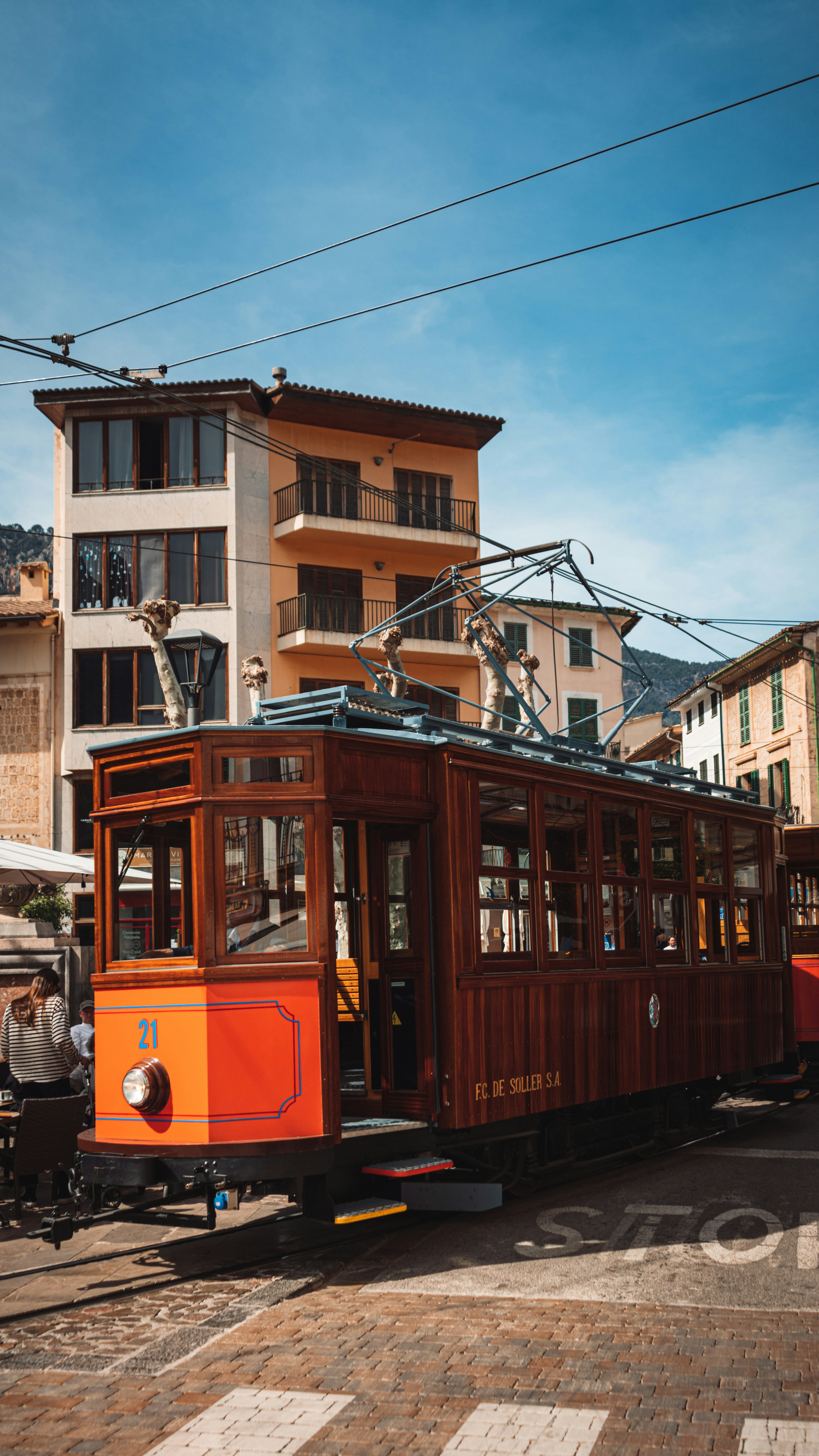 an orange trolley car on a city street