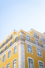 a tall yellow building with balconies on top of it