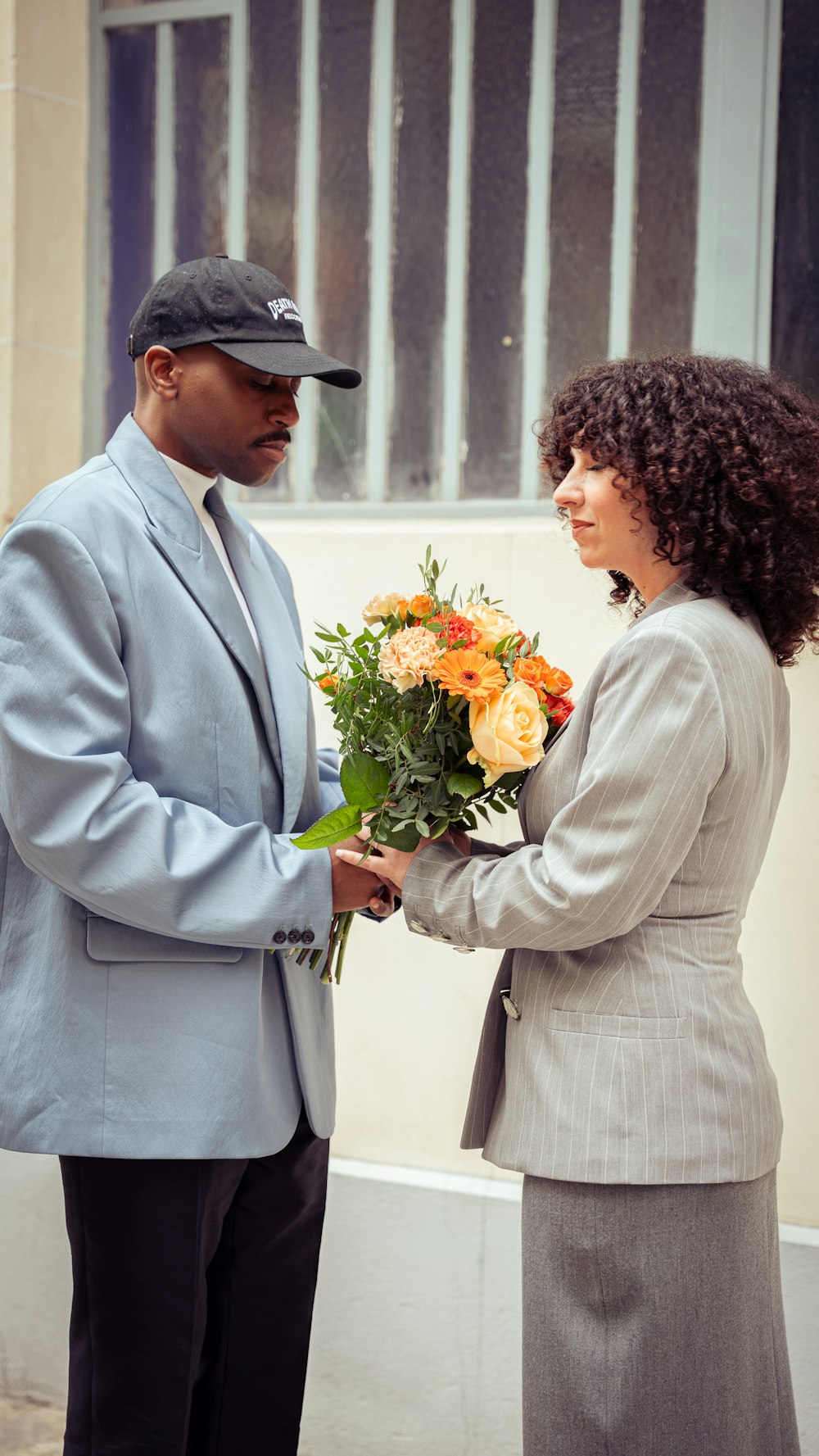 a man and a woman holding a bouquet of flowers