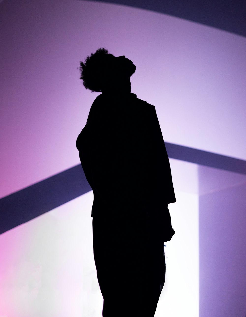 a silhouette of a person standing in front of a wall