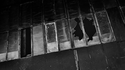 a black and white photo of a building with broken windows