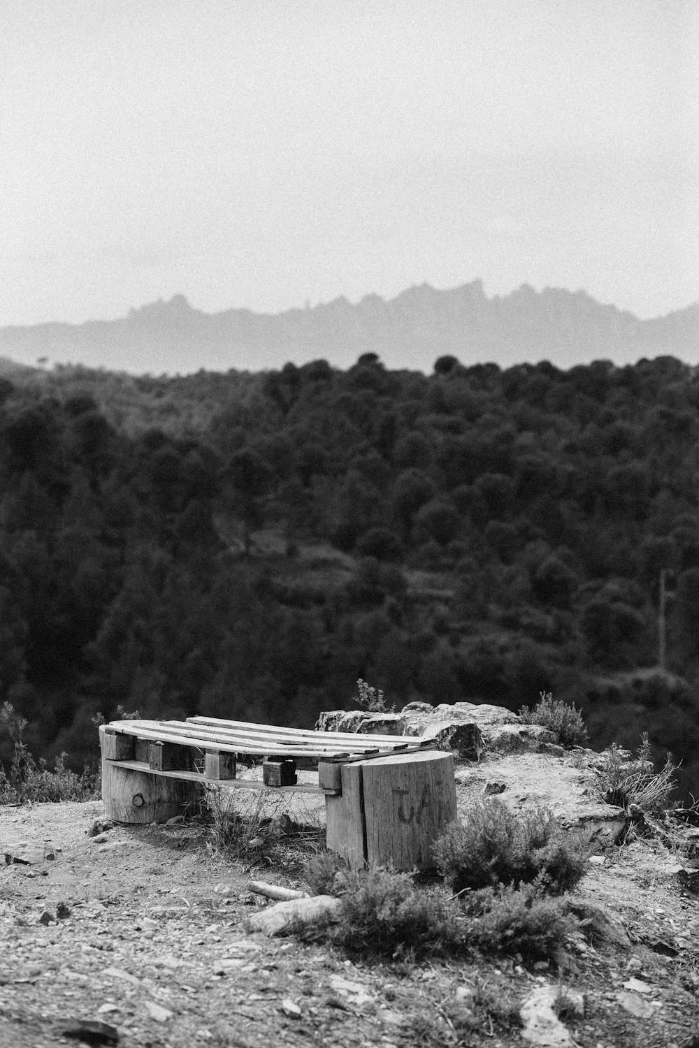 a bench sitting on top of a dirt field