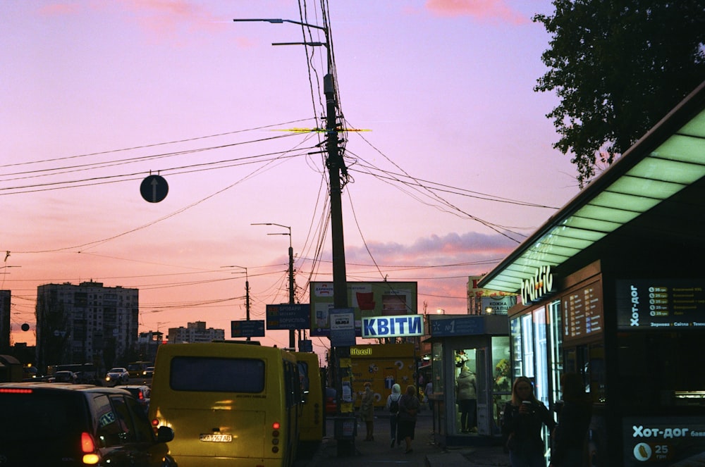 a city street at dusk with cars parked on the side of the road