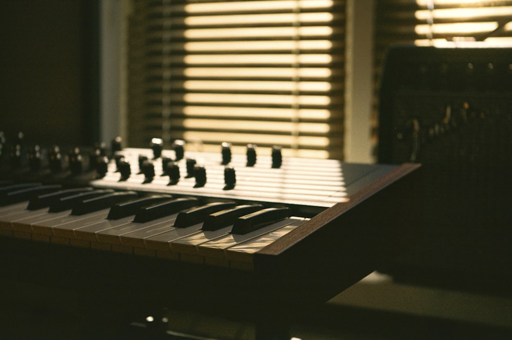 a close up of a musical keyboard near a window