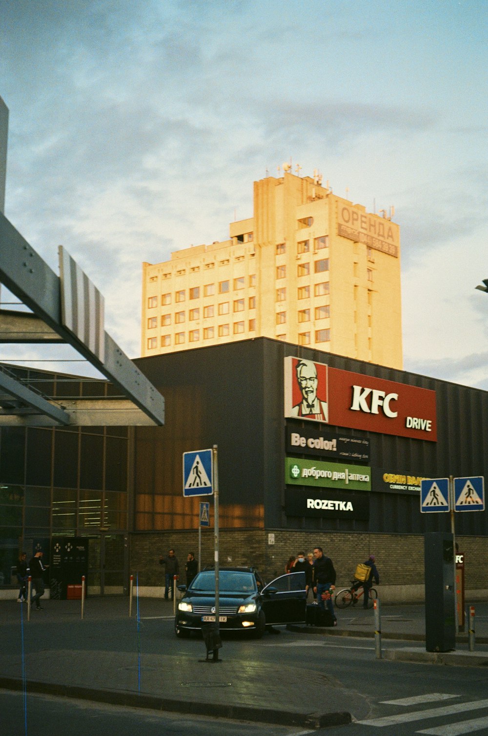 a car is parked in front of a kfc building