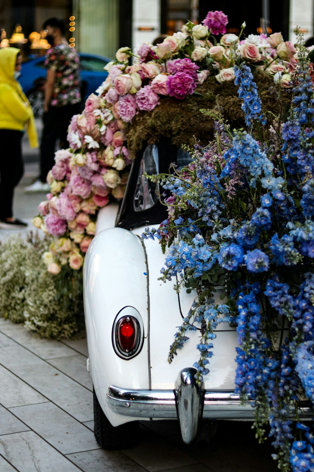 a white car with a bunch of flowers on top of it