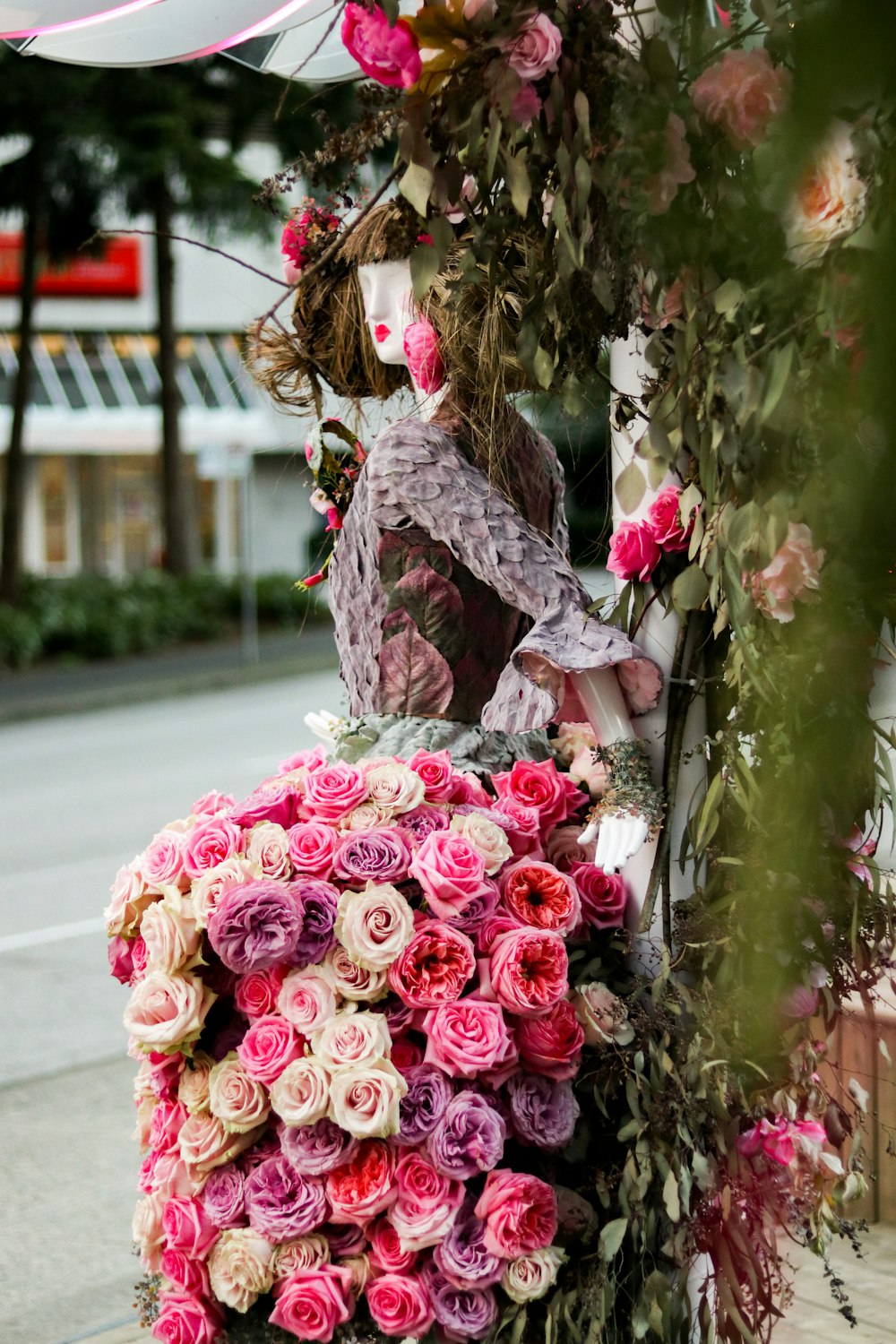 a woman is sitting on a bench covered in flowers