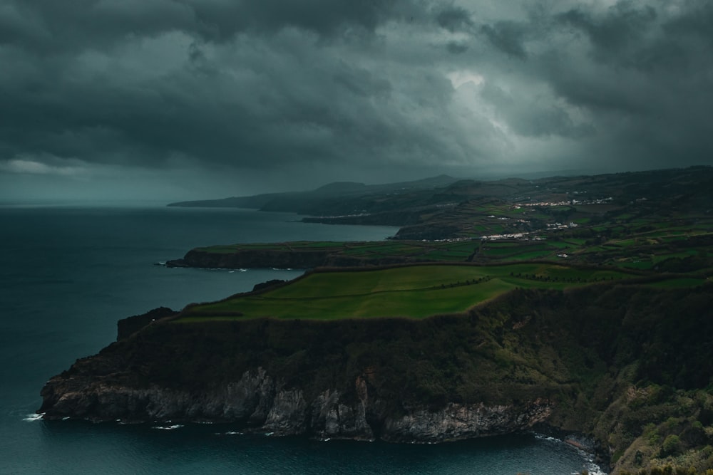 a large body of water surrounded by a lush green hillside