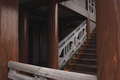 Detail of a staircase with polished wooden steps and handrails.