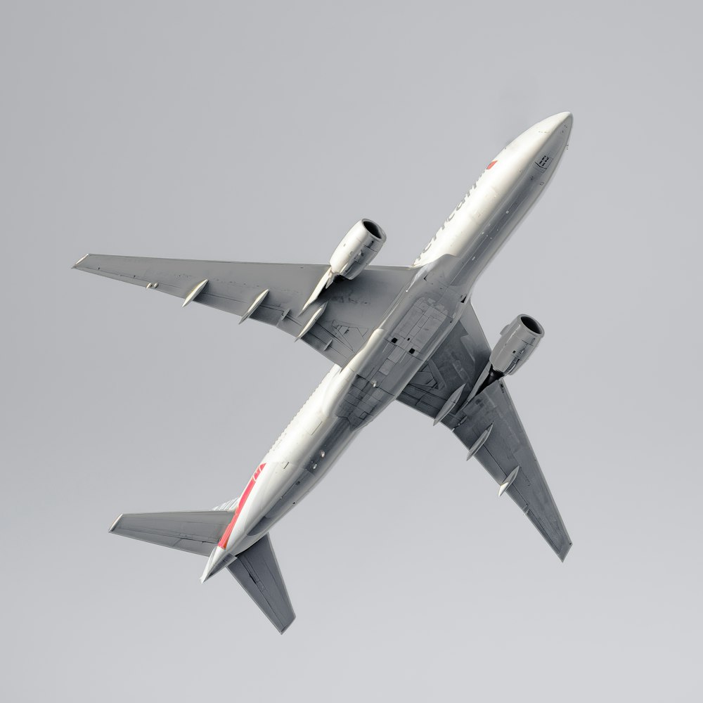 a large jetliner flying through a gray sky