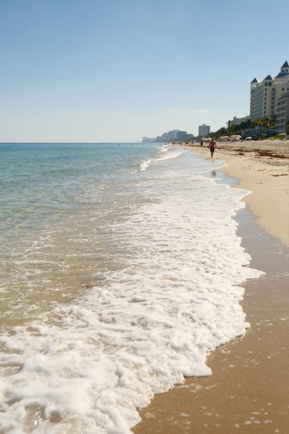 a person walking along a beach next to the ocean