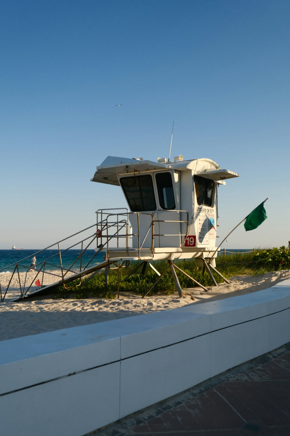 a lifeguard stand on the beach with a flag flying