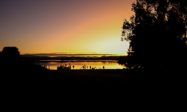 Sunset view over the Potrero de los Funes dam with silhouettes of people taking photos.