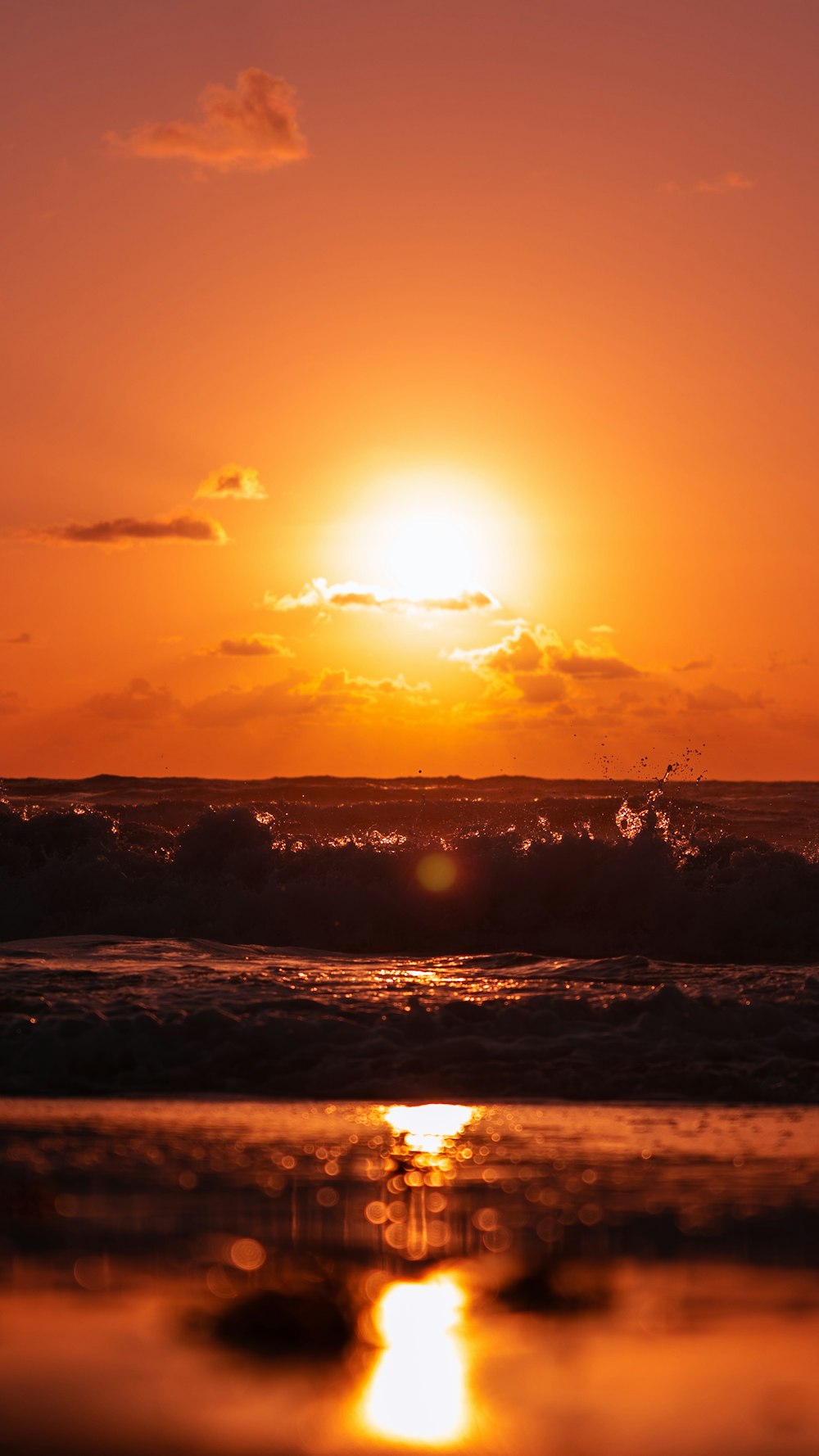 the sun is setting over the ocean with waves