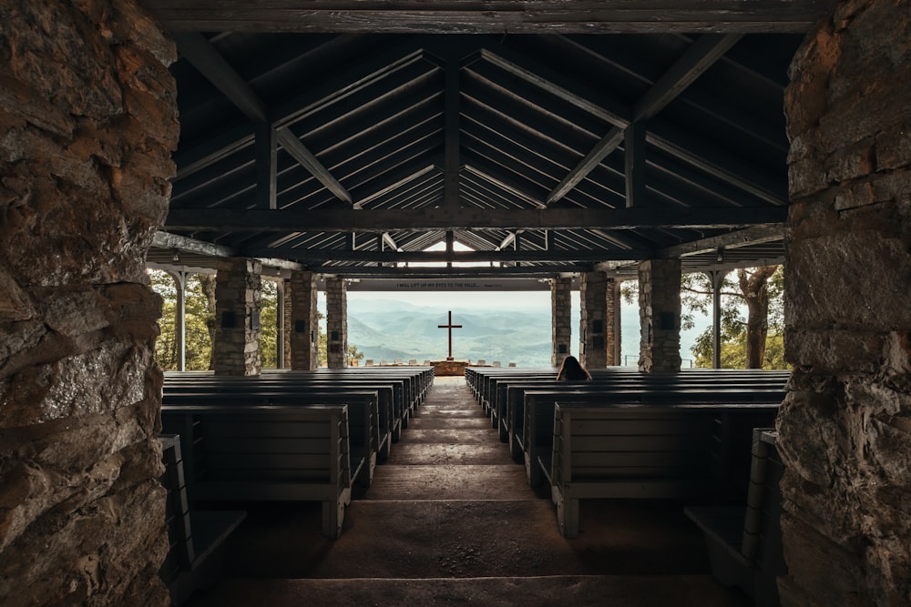 an empty church with benches and a cross