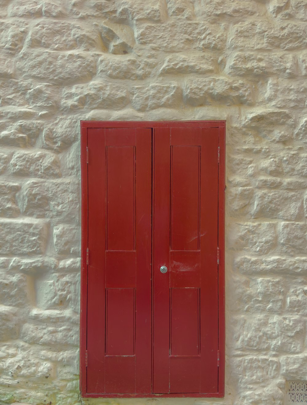 a red door on a white brick wall